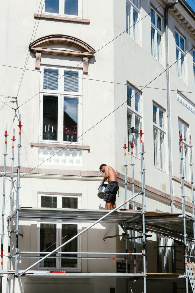 homme torse nu qui travaille sur un échafaudage