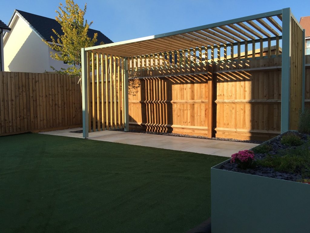 pergola en bois au fond d'un jardin